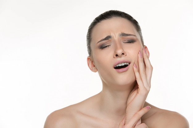 Portrait of young woman suffering from terrible tooth pain