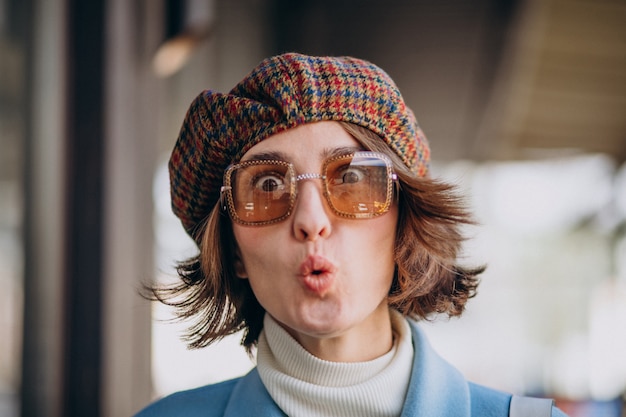 Portrait of a young woman in sunglasses and hat