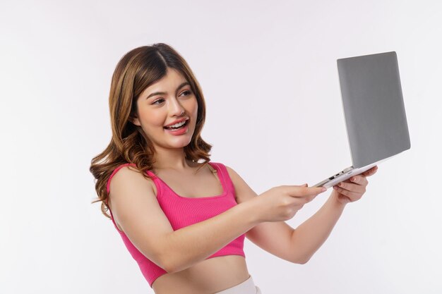 Portrait of young woman taking a photo with laptop computer isolated over white background