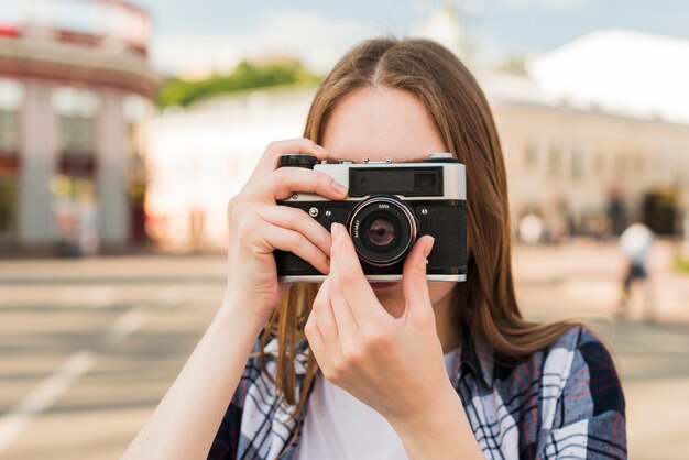 カメラで写真を撮る若い女性の肖像画