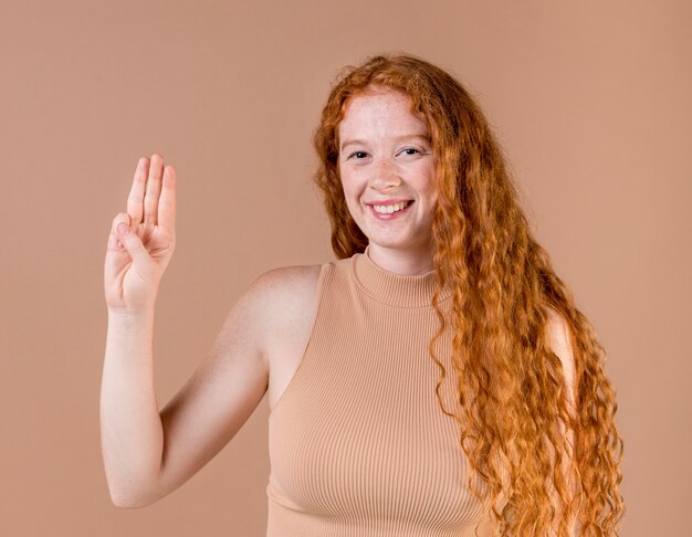 Portrait of a young woman teaching sign language