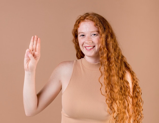 Portrait of a young woman teaching sign language