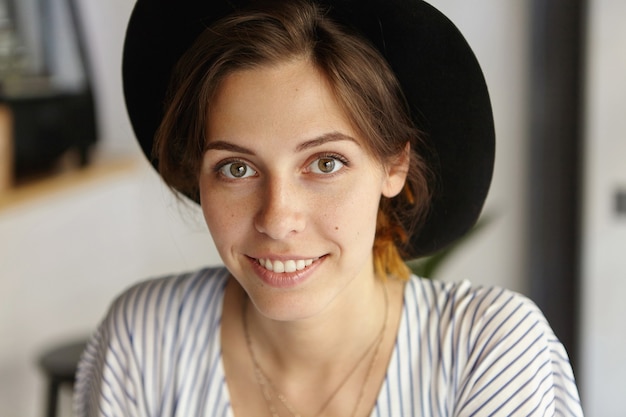 Portrait of young woman wearing big hat