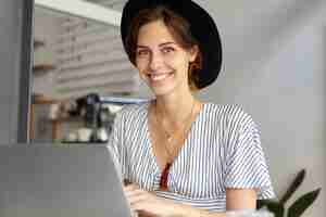 Free photo portrait of young woman wearing big hat