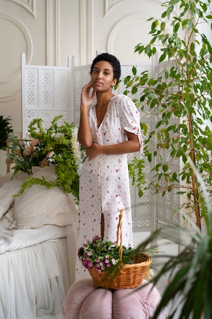 Free photo portrait of young woman wearing chic boho dress amongst flowers