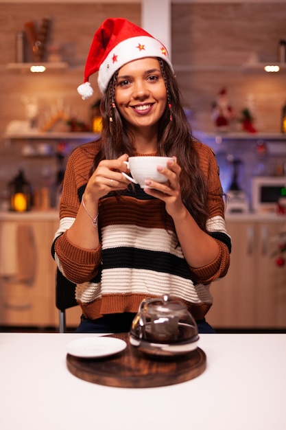 Portrait of young woman wearing santa hat and smiling