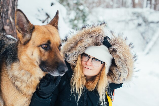 Portrait of young woman in winter coat with dog