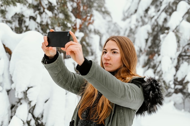 写真を撮る冬の日の肖像画の若い女性
