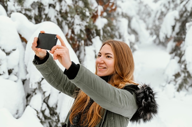 Portrait young woman on winter day taking photo