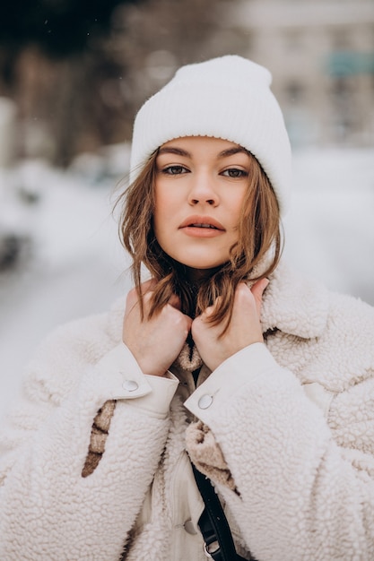 Foto gratuita ritratto di giovane donna in abito invernale al di fuori della strada