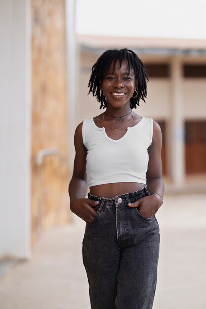 portrait of young woman with afro dreadlocks posing outside