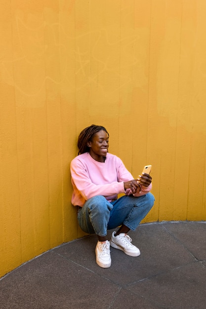 Foto gratuita ritratto di giovane donna con dreadlocks afro in posa per selfie all'aperto