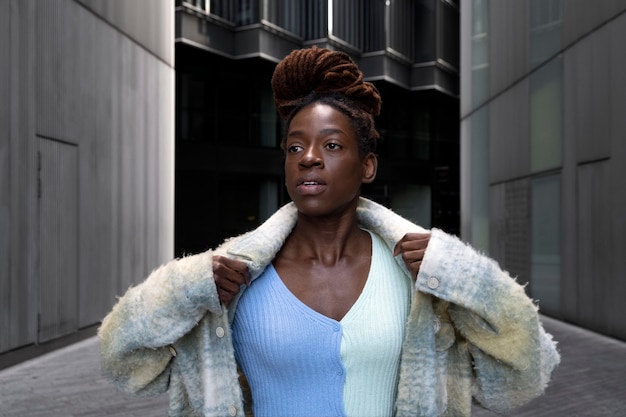 Free photo portrait of young woman with afro dreadlocks posing while out in the city