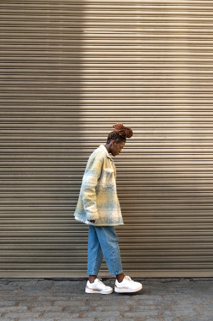 Free photo portrait of young woman with afro dreadlocks showing off her hair while in the city