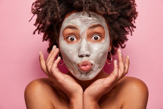 Ritratto di giovane donna con taglio di capelli afro e maschera per il viso