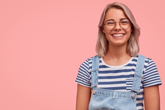 Portrait of young woman with colored hair wearing overalls