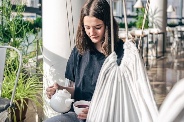 Портрет молодой женщины с чашкой чая в кафе