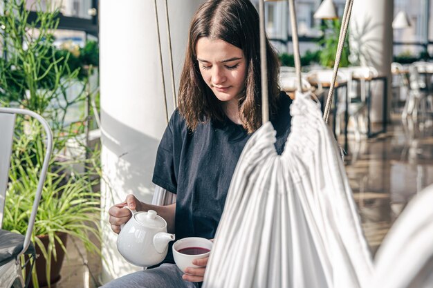 カフェでお茶を飲む若い女性の肖像画