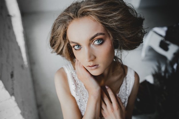 Portrait of young woman with deep blue eyes standing in the room