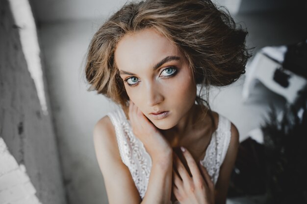 Portrait of young woman with deep blue eyes standing in the room