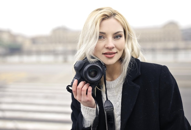 Free photo portrait of young woman with digital camera