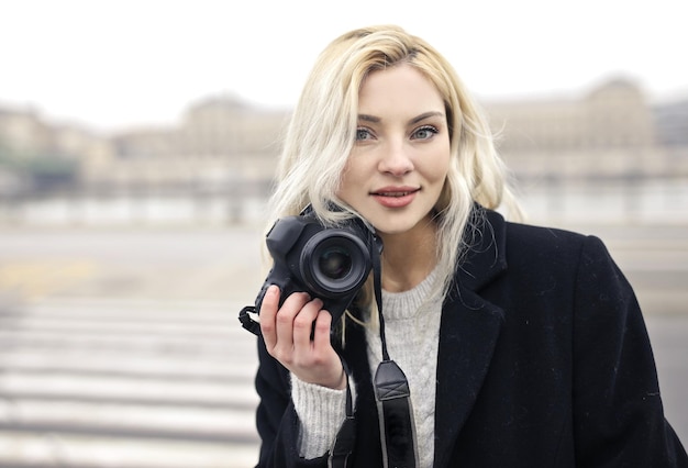 портрет молодой женщины с цифровой камерой