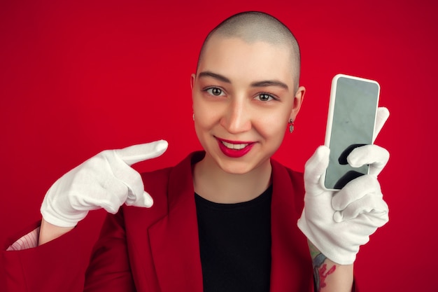 Free photo portrait of young woman with freaky appearance on red wall