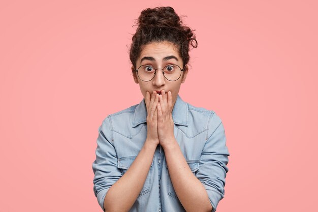 Portrait of young woman with hair in a bun and wearing denim shirt