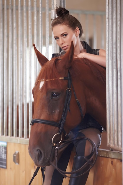 Free photo portrait of young woman with her brown horse