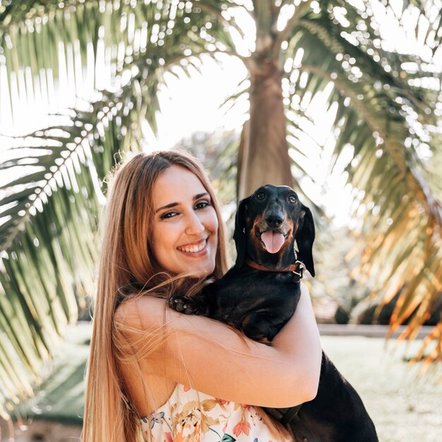 Ritratto di una giovane donna con il suo cane guardando la fotocamera