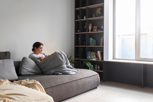 Free photo portrait of young woman with low self-esteem sitting on sofa at home