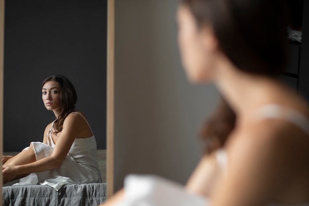 Portrait of young woman with low self-esteem with mirror