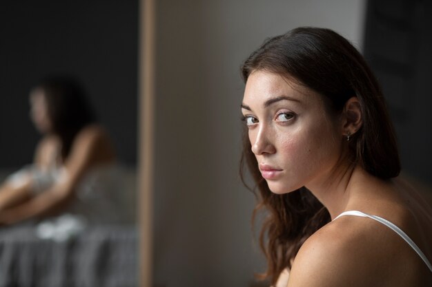鏡で自尊心の低い若い女性の肖像画