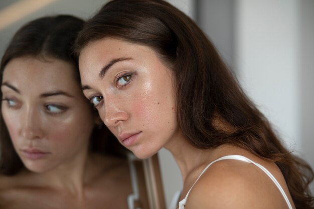 Portrait of young woman with low self-esteem with mirror