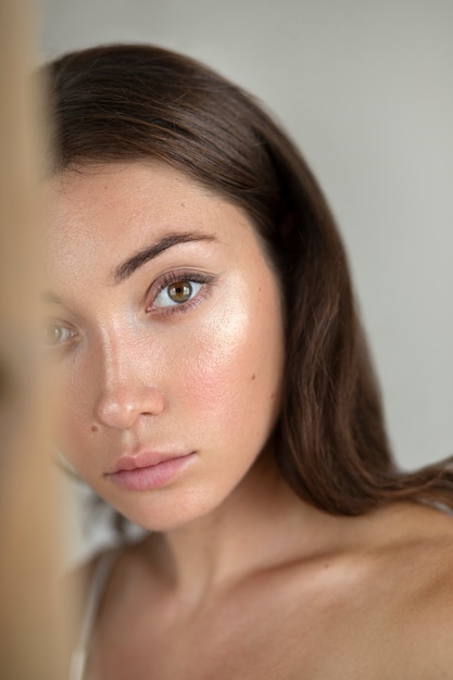 Portrait of young woman with low self-esteem with mirror