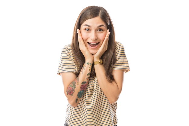 Portrait of young woman with mouth open looking surprised on white background