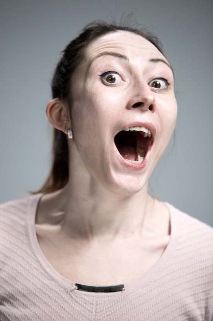 Portrait of young woman with shocked facial expression