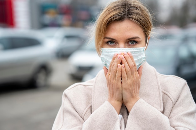 Free photo portrait of young woman with surgical mask