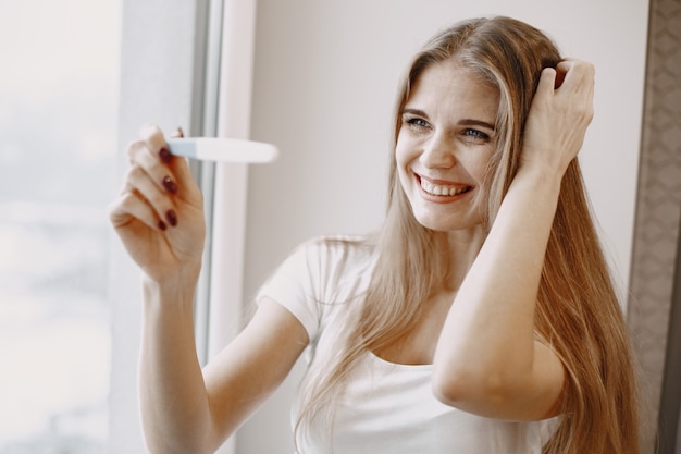 Free photo portrait of young woman with a testpack in her hand. happy woman.