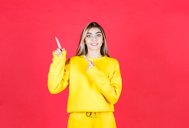 どこかを指している黄色の衣装で若い女性の肖像画