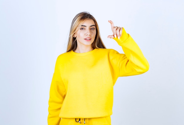 Portrait of young woman in yellow outfit posing and standing