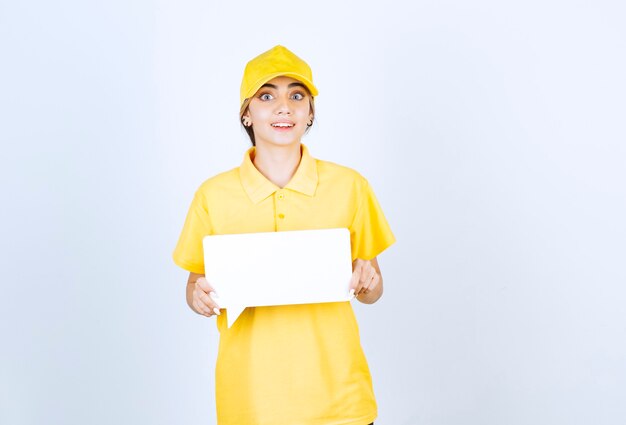 Portrait of a young woman in yellow uniform with an empty speech bubble . 