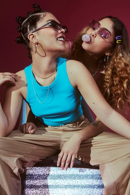 Portrait of young women in 2000s fashion style posing with bubblegum