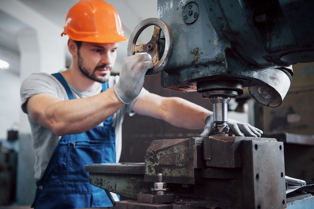 Foto gratuita ritratto di un giovane operaio in un cappello duro in un grande impianto di lavorazione dei metalli.