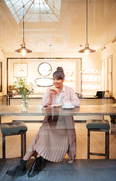 Foto gratuita ritratto di una giovane donna seduta al moderno caffè