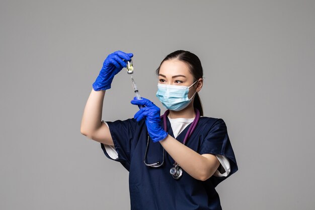 Portrat of young Asian female doctor drawing Covid-19 vaccine from vaccine bottle