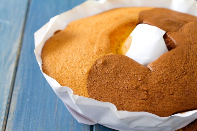 Premium Photo Portuguese Cake Pao De Lo On White Paper On Blue Wooden Surface