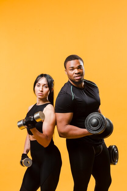 Posing athletes holding weights