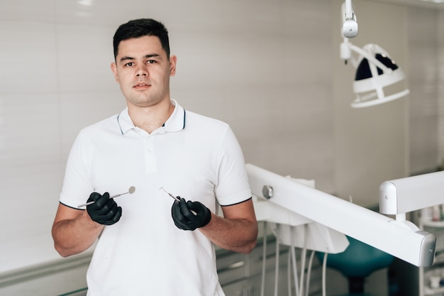 Free photo posing dentist holding equipment