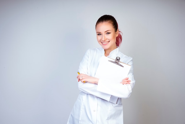 Foto gratuita posa della ragazza in uniforme bianca del medico